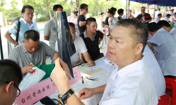 图为台州市民营医院协会会长、骨伤科名中医、我院董事长章友棣生生正在为市民义诊。.jpg